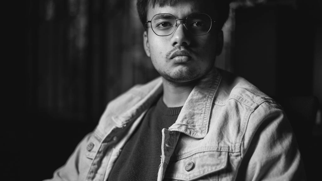 Portrait of the founding partner and former Reuters business-desk journalist, treated as a navy duotone editorial headshot.